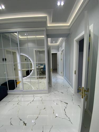 a room with a white marble floor and windows at Luxury Apartment Tashkent City boulevard Happy Home in Tashkent
