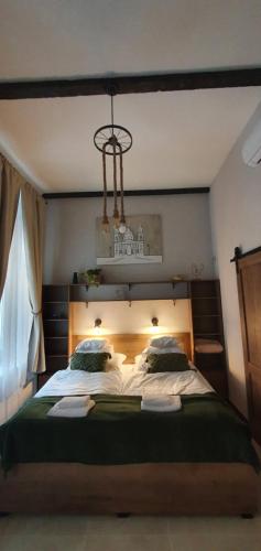 ein Schlafzimmer mit einem großen Bett mit einem Kronleuchter darüber in der Unterkunft Ó 38 Luxe Loft in Budapest