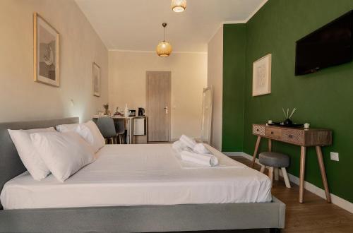 a bedroom with a bed with a green wall at SEITAN PAZAR (Olive/Akrokeramos) in Preveza