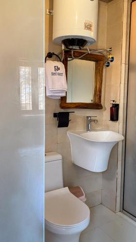 a bathroom with a sink and a toilet and a mirror at Hanging Terraces المدرجات المعلقة in Al ‘Aqar