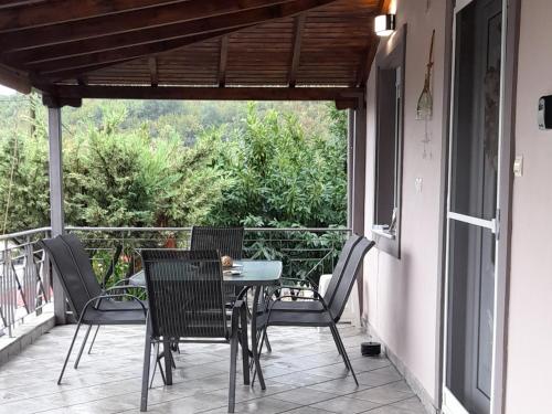 een patio met een tafel en stoelen op een balkon bij Alex House 