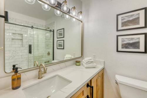 La salle de bains blanche est pourvue d'un lavabo et d'un miroir. dans l'établissement Inviting Tahoe Escape, à Incline Village