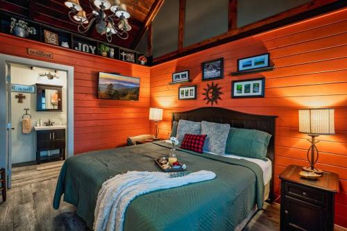 a bedroom with a bed in a room with wooden walls at Lazy Fox Hideout in Sevierville