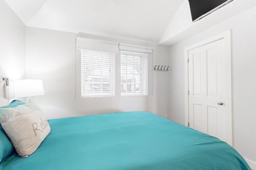 a white bedroom with a green bed and windows at Berni's Ocean View Castle - The Potter's Wheel in Oceanside