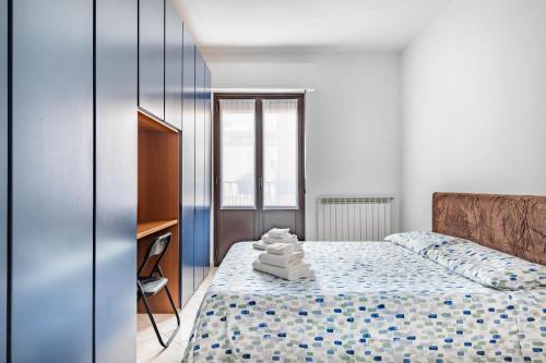 a bedroom with a bed with towels on it at Milan - Bocconi e Navigli - Spacious 3BR Apartment 95 m - Free Parking in Milan