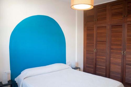 een slaapkamer met een blauw bed en houten kasten bij Localización inmejorable con garaje incluido in Puerto de la Cruz