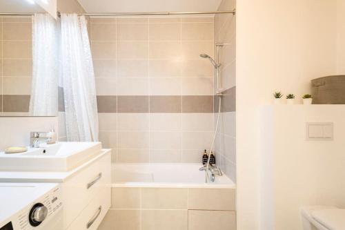 y baño con bañera, lavamanos y ducha. en Apartment in Ferney near Geneva airport / UN / WHO en Ferney-Voltaire
