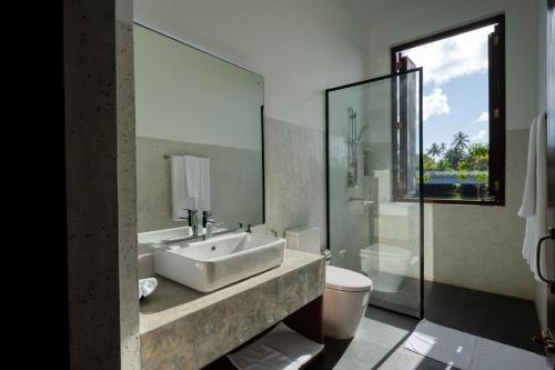 a bathroom with a sink and a toilet at Sitara Weligama in Weligama