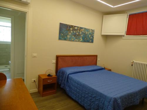 Un dormitorio con una cama azul y una mesa en Il Gallo, en San Casciano in Val di Pesa