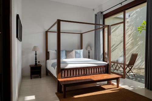 um quarto com uma cama de dossel e uma mesa de madeira em Sitara Weligama em Weligama