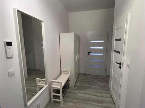 a dressing room with a mirror and a stool at Apartamenty Przy Deptaku in Świnoujście