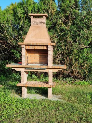 a wooden bird house sitting on top of a field at Appartement à la campagne avec piscine in Durtal