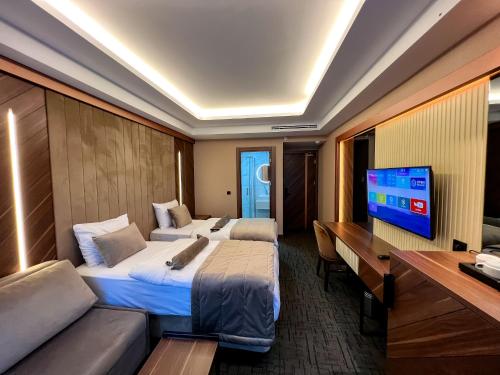 a hotel room with two beds and a desk and a television at THE PARK HOTEL in Istanbul
