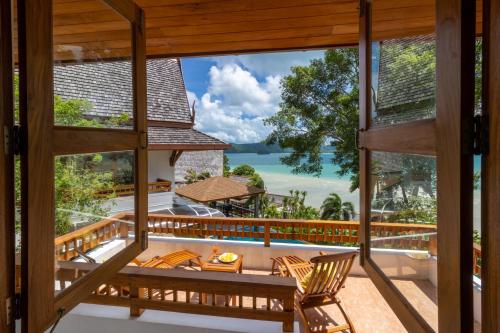 a view of the ocean from the balcony of a villa at 悬崖别墅 无边海景 直达海滩 五卧泰式独栋私人泳池别墅 超漂亮日出 in Phuket Town