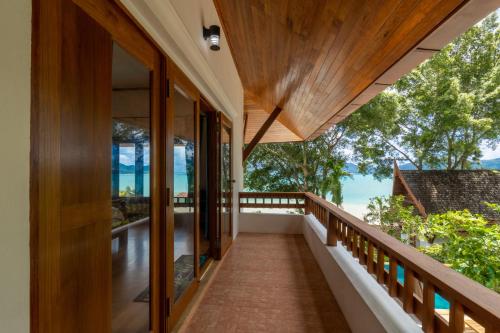 a balcony of a house with a view of the ocean at 悬崖别墅 无边海景 直达海滩 五卧泰式独栋私人泳池别墅 超漂亮日出 in Phuket Town