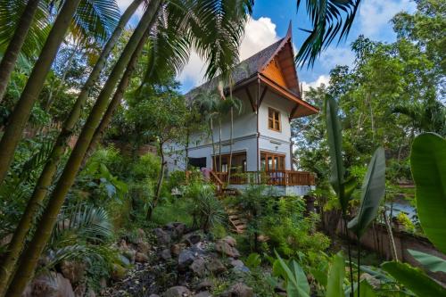 a house in the jungle with palm trees at 悬崖别墅 无边海景 直达海滩 五卧泰式独栋私人泳池别墅 超漂亮日出 in Phuket Town
