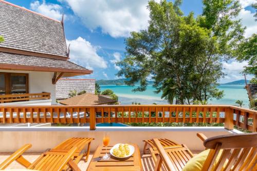 a deck with chairs and a table with a view of the ocean at 悬崖别墅 无边海景 直达海滩 五卧泰式独栋私人泳池别墅 超漂亮日出 in Phuket Town