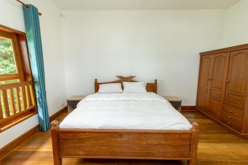 a bedroom with a bed with white sheets and a window at 悬崖别墅 无边海景 直达海滩 五卧泰式独栋私人泳池别墅 超漂亮日出 in Phuket Town