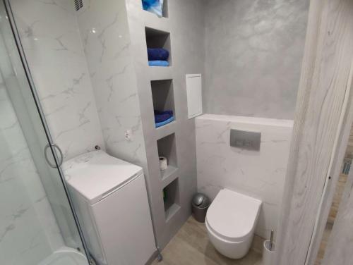 biała łazienka z toaletą i prysznicem w obiekcie Mieszkanie w Mońkach w mieście Mońki