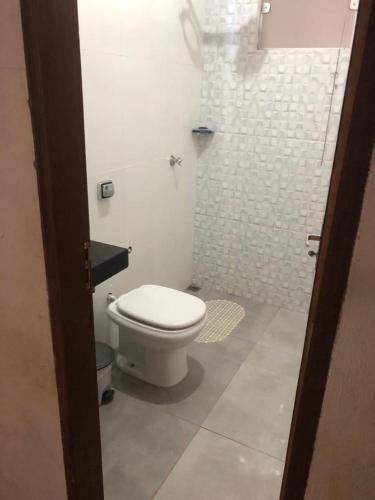 a bathroom with a white toilet in a room at Casa do Beto in Pirenópolis