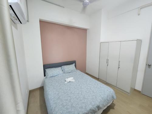 a bedroom with a bed with a stuffed animal on it at Praicon Executive Suite in Butterworth