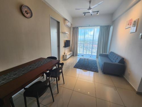 a living room with a table and a blue couch at Praicon Executive Suite in Butterworth