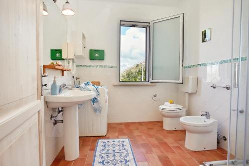 スコペッロにあるVilla Conchiglia - Scopello-Villasのバスルーム(洗面台、トイレ付)、窓が備わります。