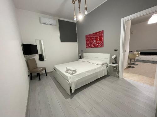 Schlafzimmer mit einem Bett, einem Schreibtisch und einem TV in der Unterkunft Home Serpico in Scisciano