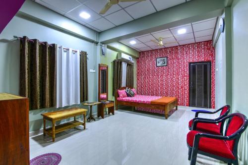 a room with a bed and a red wall at OCEANS BREEZE in Port Blair