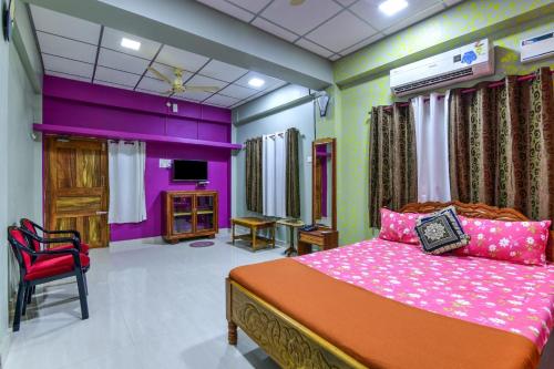 a bedroom with a bed with pink and purple walls at OCEANS BREEZE in Port Blair