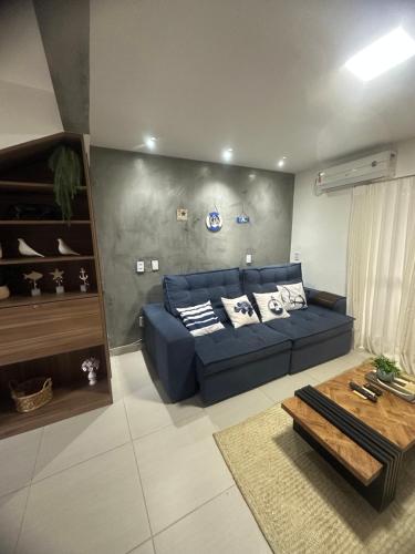 a living room with a blue couch and a table at Village ITACIMIRIM SUMMER HOUSE in Camaçari