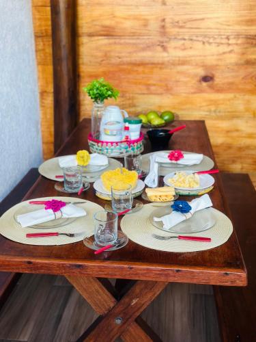 a wooden table with plates of food on it at Village ITACIMIRIM SUMMER HOUSE in Camaçari