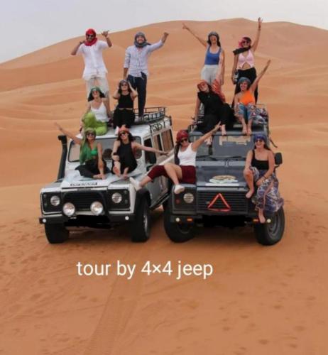 a group of people riding in the desert at Holiday Desert Camp in Merzouga