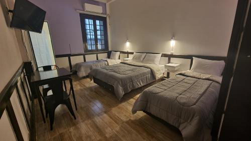 a hotel room with two beds and a television at Nuevo Hotel Aramaya in Montevideo