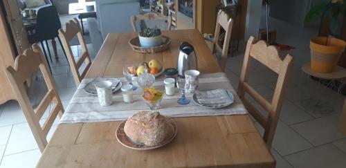 una mesa de madera con comida encima en Chambre d'hôtes de la voie bleue., en Plouguerneau
