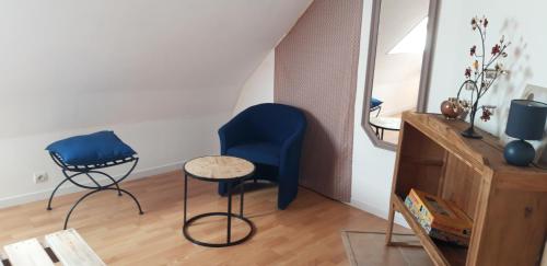 um quarto com uma cadeira azul, uma mesa e um espelho em Chambre d'hôtes de la voie bleue. em Plouguerneau