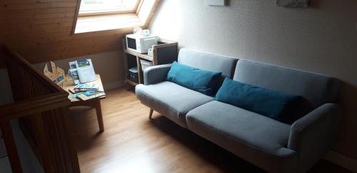 uma sala de estar com um sofá azul e uma janela em Chambre d'hôtes de la voie bleue. em Plouguerneau