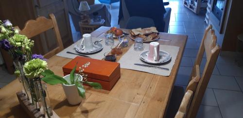 uma mesa de madeira com pratos de comida em Chambre d'hôtes de la voie bleue. em Plouguerneau