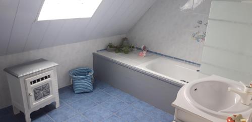 uma casa de banho com uma banheira e um lavatório em Chambre d'hôtes de la voie bleue. em Plouguerneau