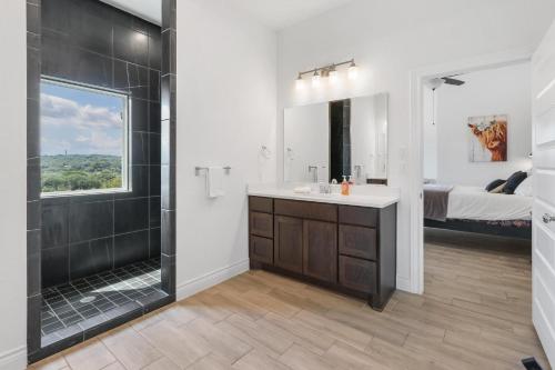 a bathroom with a shower and a sink and a mirror at Canary Lakehouse in Canyon Lake