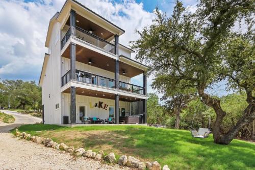 a large white house with a tree in front of it at Canary Lakehouse in Canyon Lake