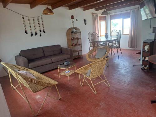 uma sala de estar com um sofá, cadeiras e uma mesa em Linda casa de campo en Mejia - Arequipa em Mejia