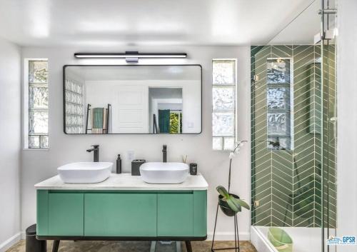 een badkamer met 2 wastafels en een spiegel bij wonderfully reimagined 3bd 2bath mid-century palm springs home in Palm Springs