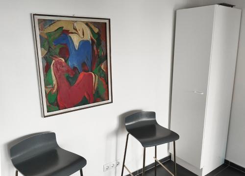 two black stools in a room with a painting on the wall at Ruhige zentrale Lage in Bad Honnef in Bad Honnef am Rhein
