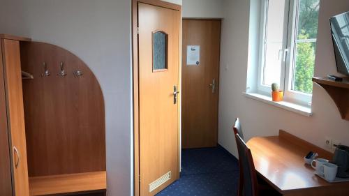 Zimmer mit einem Schreibtisch und einer Holztür in der Unterkunft Noclegi Agape in Szczecin-Płonia