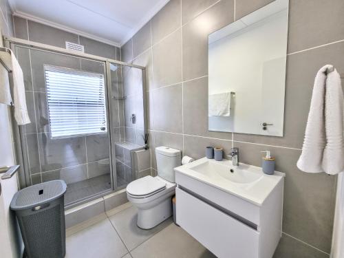 a bathroom with a toilet and a sink and a shower at Apartment 276 Ballito Village in Ballito
