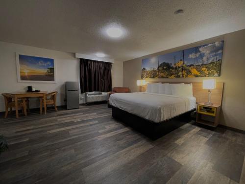 una camera d'albergo con letto e scrivania di Days Inn & Suites by Wyndham Kaukauna WI a Kaukauna