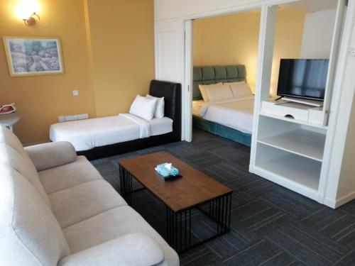 a living room with two beds and a couch and a tv at Kl Continew Suite At Times Square in Kuala Lumpur