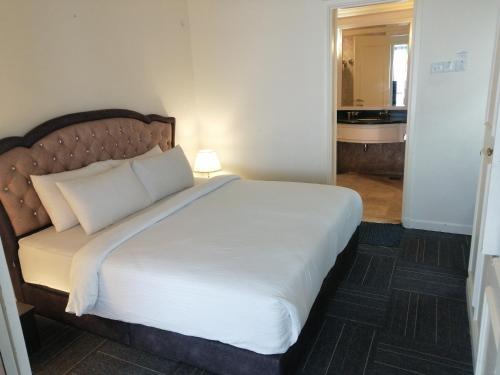 a bedroom with a large bed with white sheets at Kl Continew Suite At Times Square in Kuala Lumpur