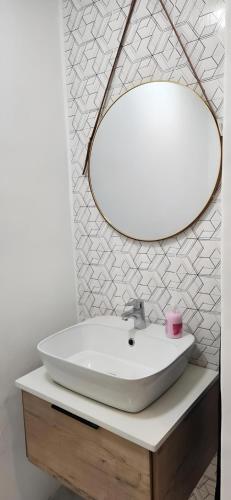a bathroom with a white sink and a mirror at Lagoon Lodge in Cape Town